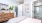 a bedroom with a bed and a plant on the wall