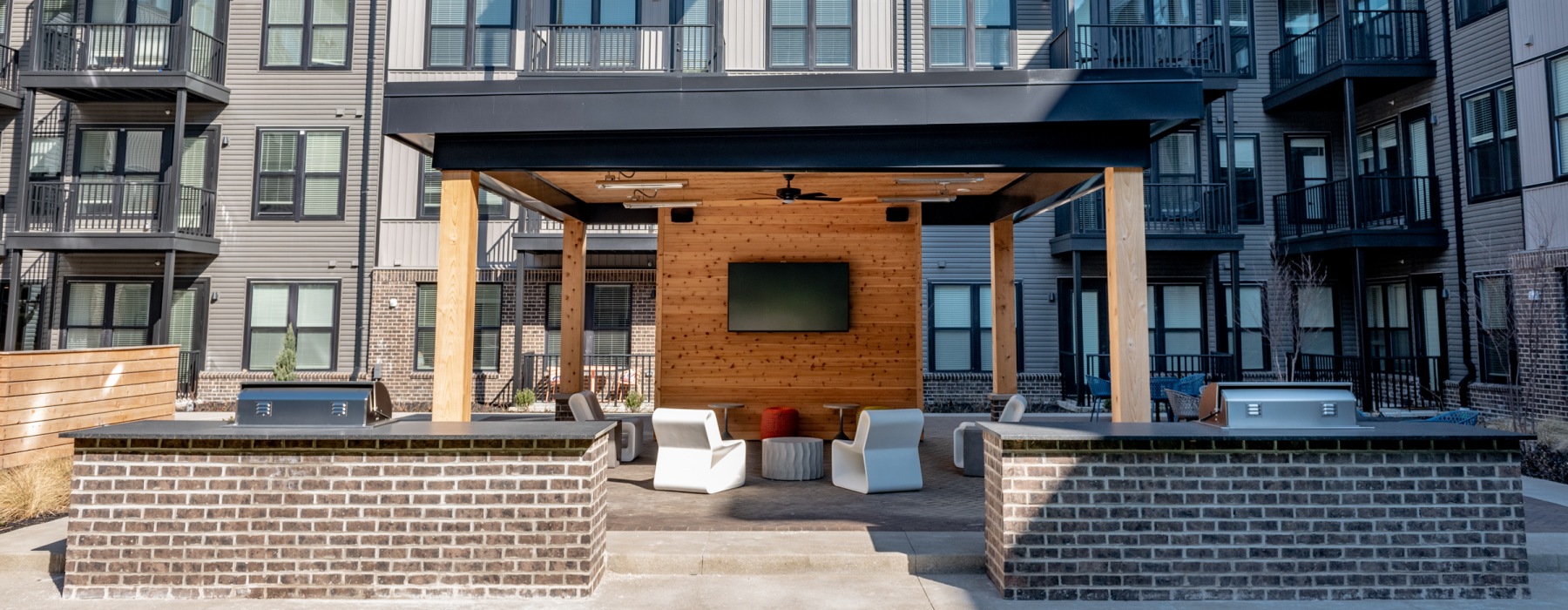 Outdoor courtyard with fireplace, TV, and lounge seating at Founders Park apartments in the Harrison West neighborhood of Columbus, Ohio
