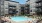 a group of people sitting around a pool in front of a building